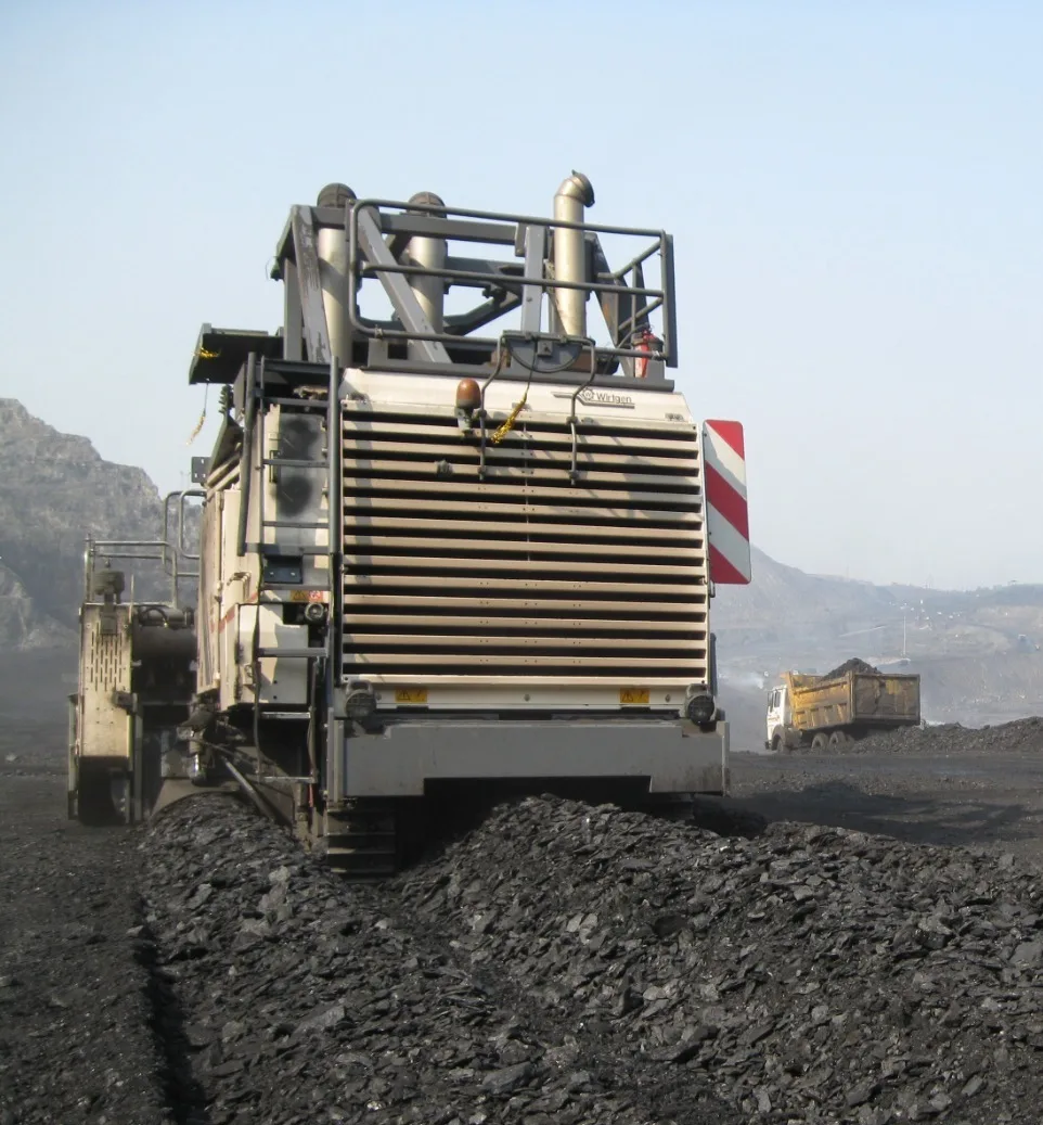 Heavy mining machinery loading coal at an active open-pit mine, representing mining and resource companies